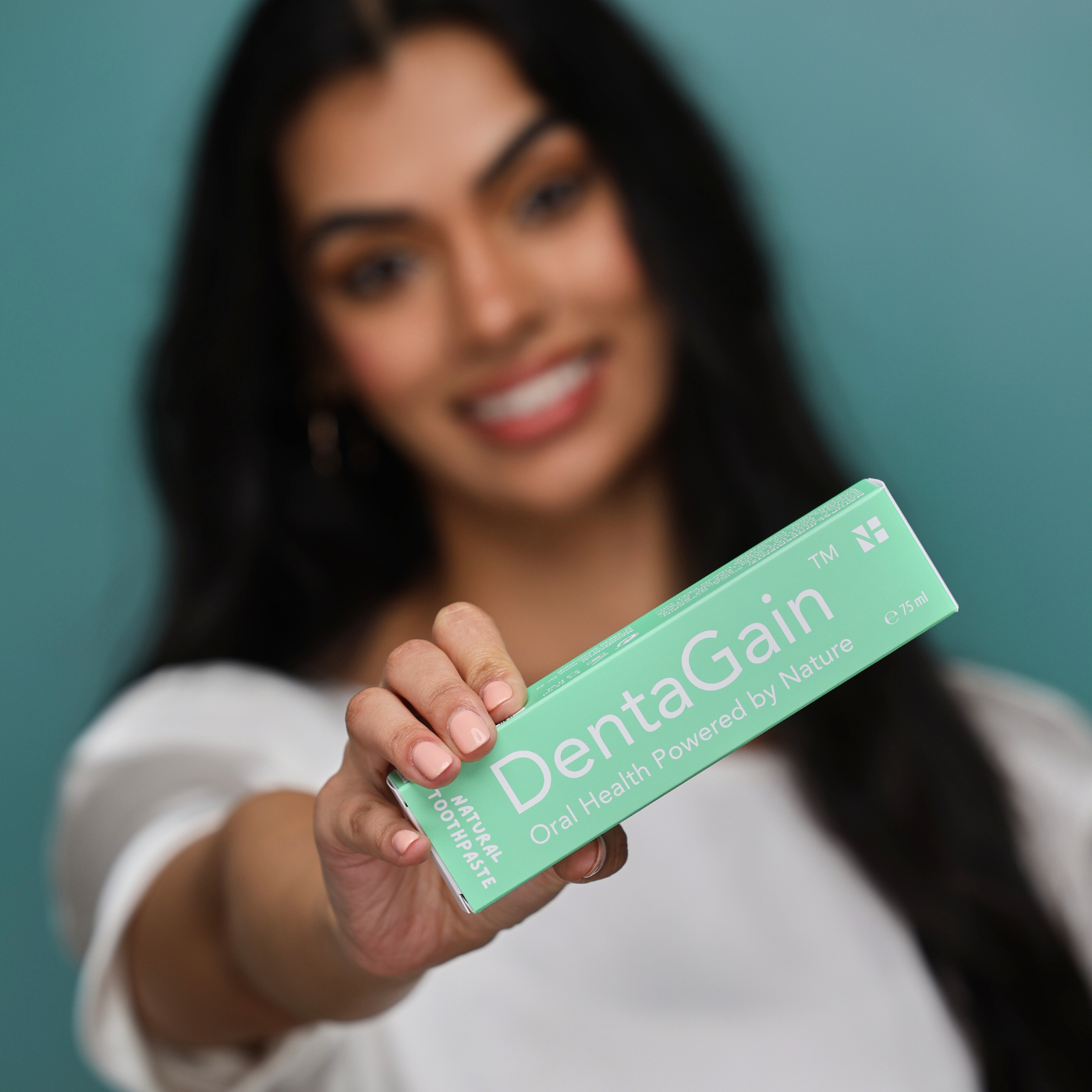 Woman holding DetaGain natural toothpaste