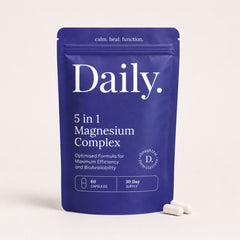 A blue stand-up pouch labeled 'Daily. 5 in 1 Magnesium Complex' on a light beige background, with two white capsules placed in front.