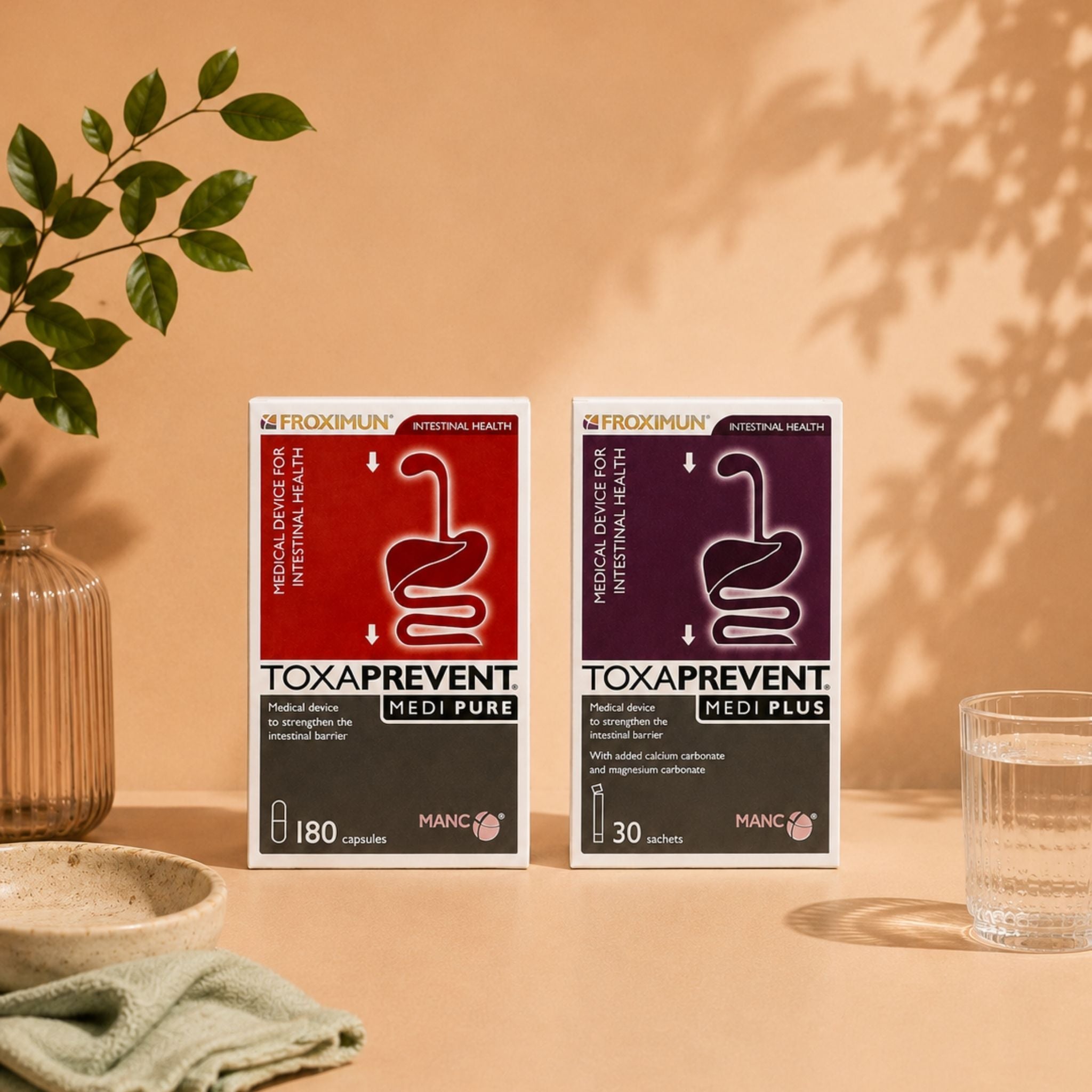 Two boxes of Toxa Prevent dietary supplements, Medi Pure and Medi Plus, displayed on a beige surface with a warm shadow cast on the background wall, flanked by a glass vase with green leaves and a glass of water.